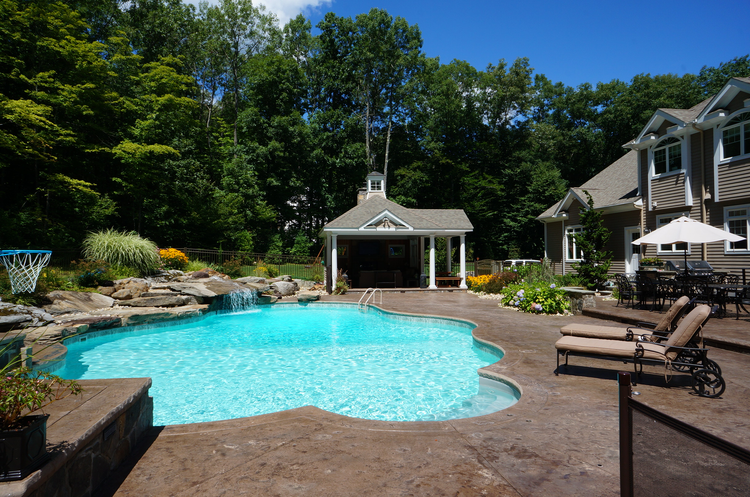 Custom inground pool with rock fountain